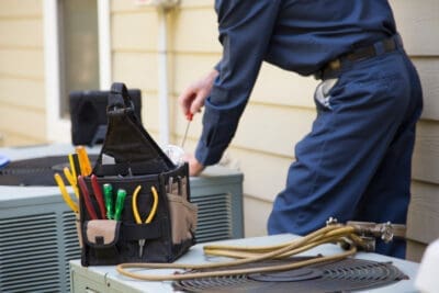 An HVAC technician working on an air conditioner