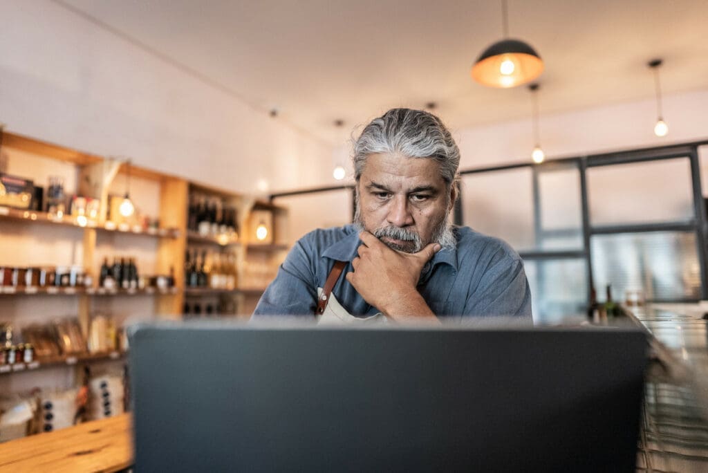 A small business owner in their shop and working on a computer