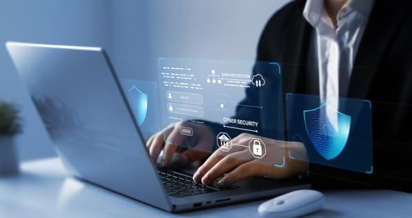 A man using a laptop with security and login information on the screen