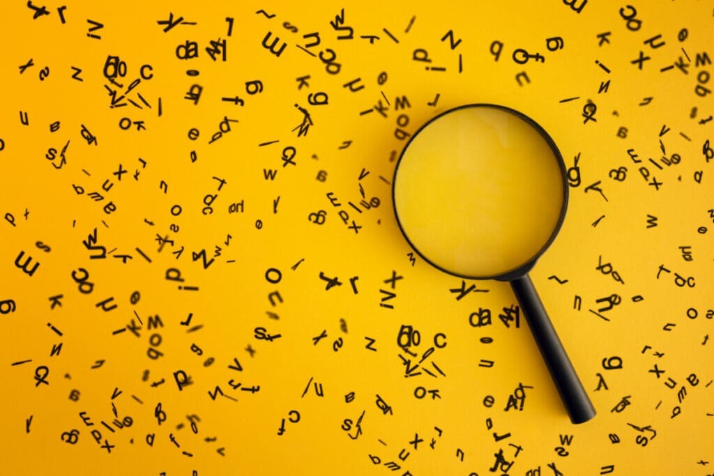 A magnifying glass surrounded by multiple random letters