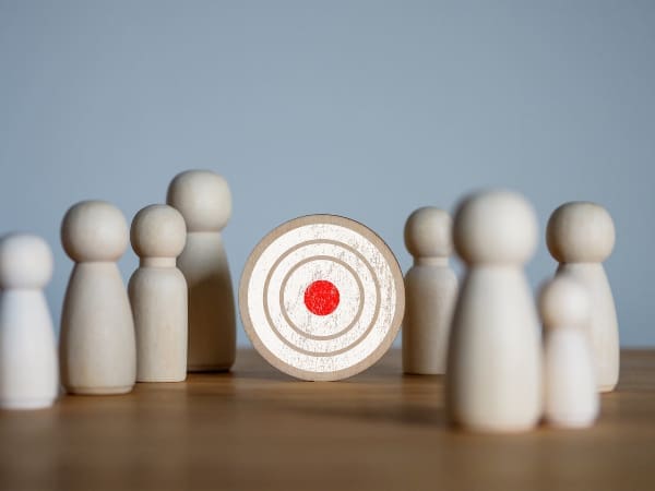 A group of wooden figures around a target