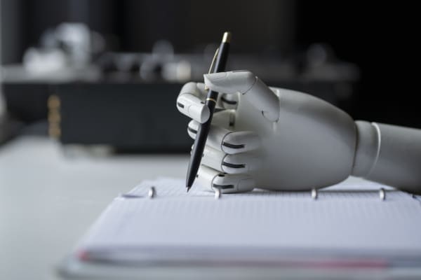 A robot arm using a pen to write on paper