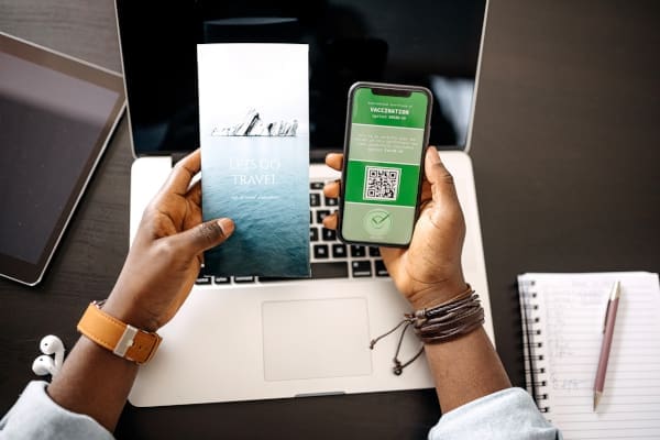 A person using a smart phone while looking at a brochure